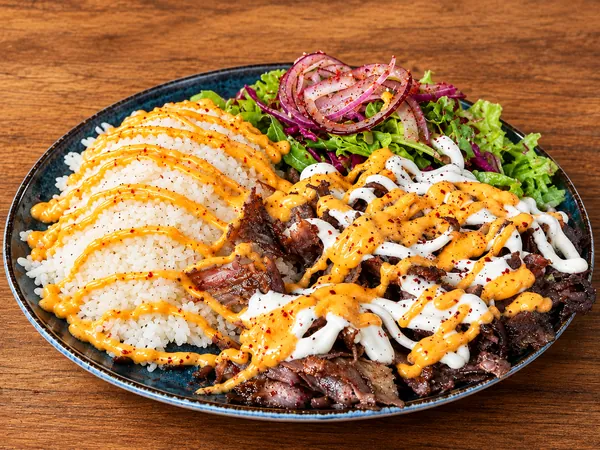 Steakfleisch mit Reis, Salat und Soßen